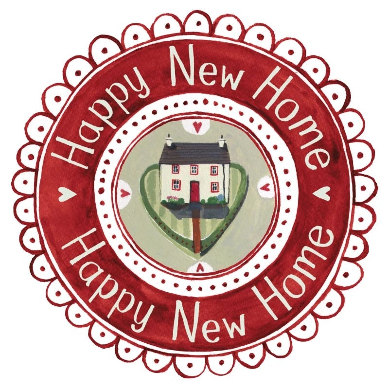 A circular decorative wreath with a scalloped red border and the words 'Happy New Home' repeated around the outer ring. The center shows a small house above a green heart shape on a light background.