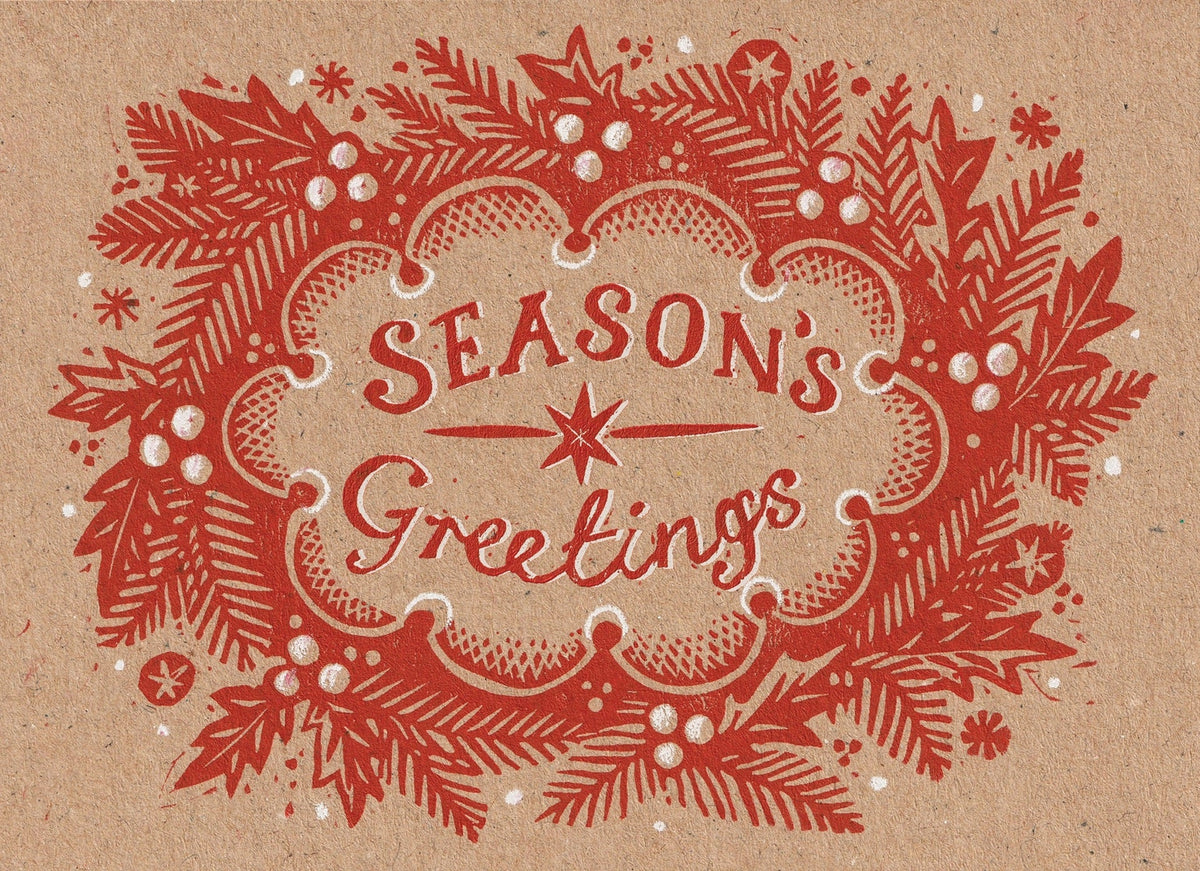 A vintage-style holiday greeting card design with the words “Season’s Greetings” in red lettering, surrounded by a red wreath of pine branches, berries, and snowflake motifs on a warm tan background.