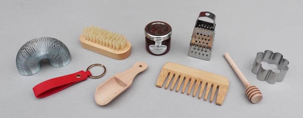 Example of Christmas cracker gifts including wooden comb, nail brush, mini grater and mini jar of jam. 