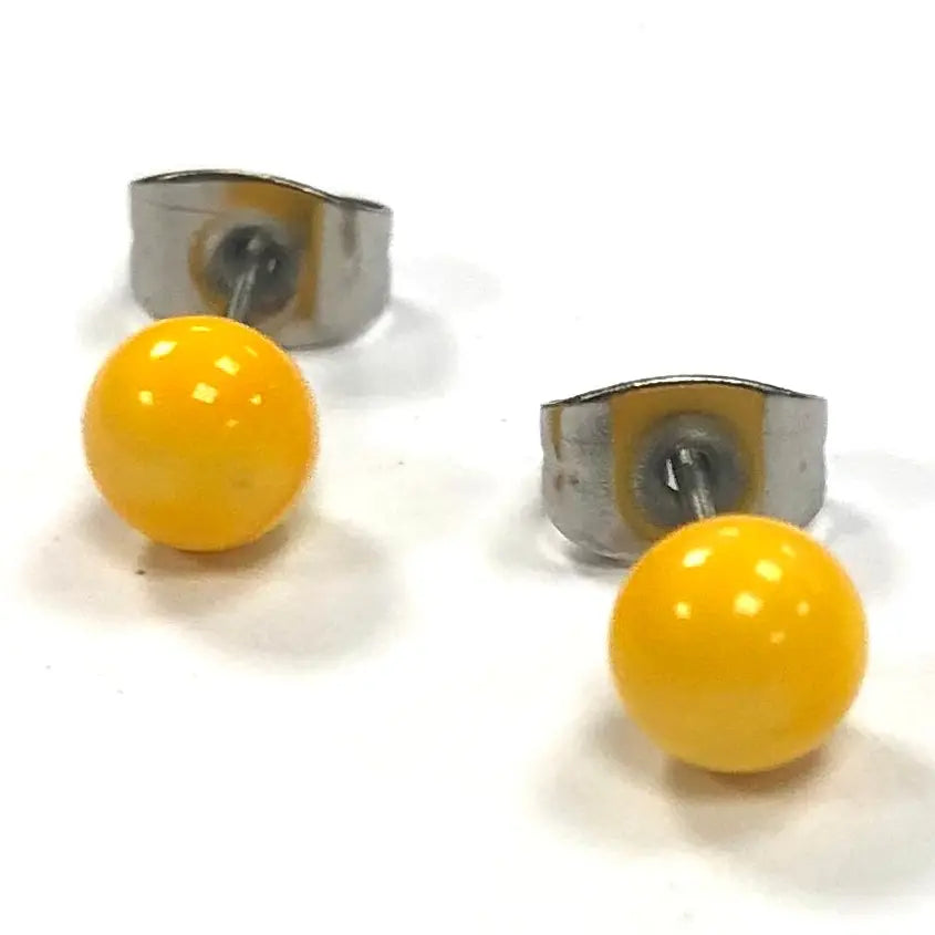Yellow round glass earrings with silver posts on a white background