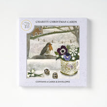 A boxed set of 6 Christmas cards featuring a robin visitor on a snowy branch out side a window with a vase of flowers.