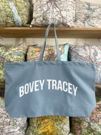 Blue tote bag with 'BOVEY TRACEY' text on a background of vintage maps
