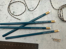 Four teal coloured pencils each with a camping phrase on.