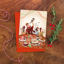 Greeting card with festive illustration of four people enjoying a Christmas meal at a table on a wooden surface with decorative elements.
