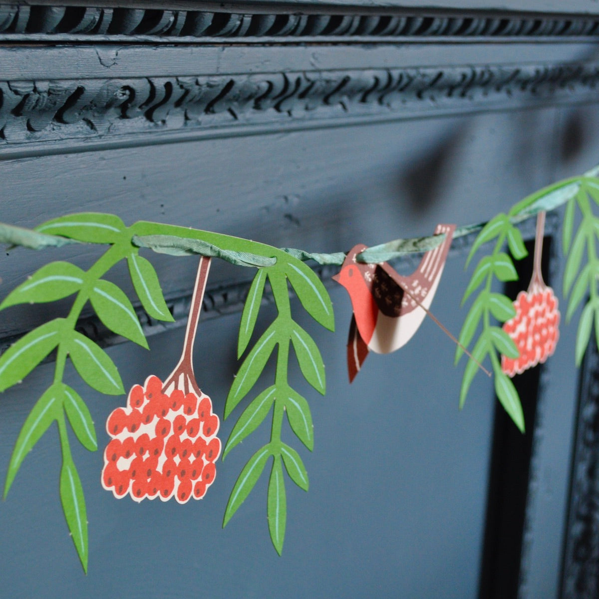 Decorative paper garland with green leaves and red berries by Cambridge Imprint