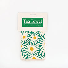 A packaged tea towel with a green header card reading 'Tea Towel' and a daisy pattern in green, cream, and yellow, shown on a plain white background.