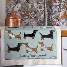 Tea Towel featuring darling dachshunds print in an embroidered style hanging in a kitchen