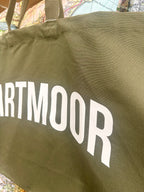 Green bag with 'DARTMOOR' printed on it, close-up view.