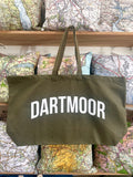 Green tote bag with 'Dartmoor' text on a background of maps