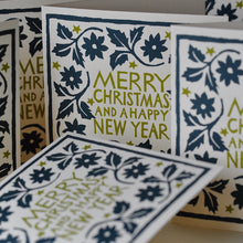 Decorative Christmas card with floral patterns and 'Merry Christmas and a Happy New Year' text in black and gold on a cream background.