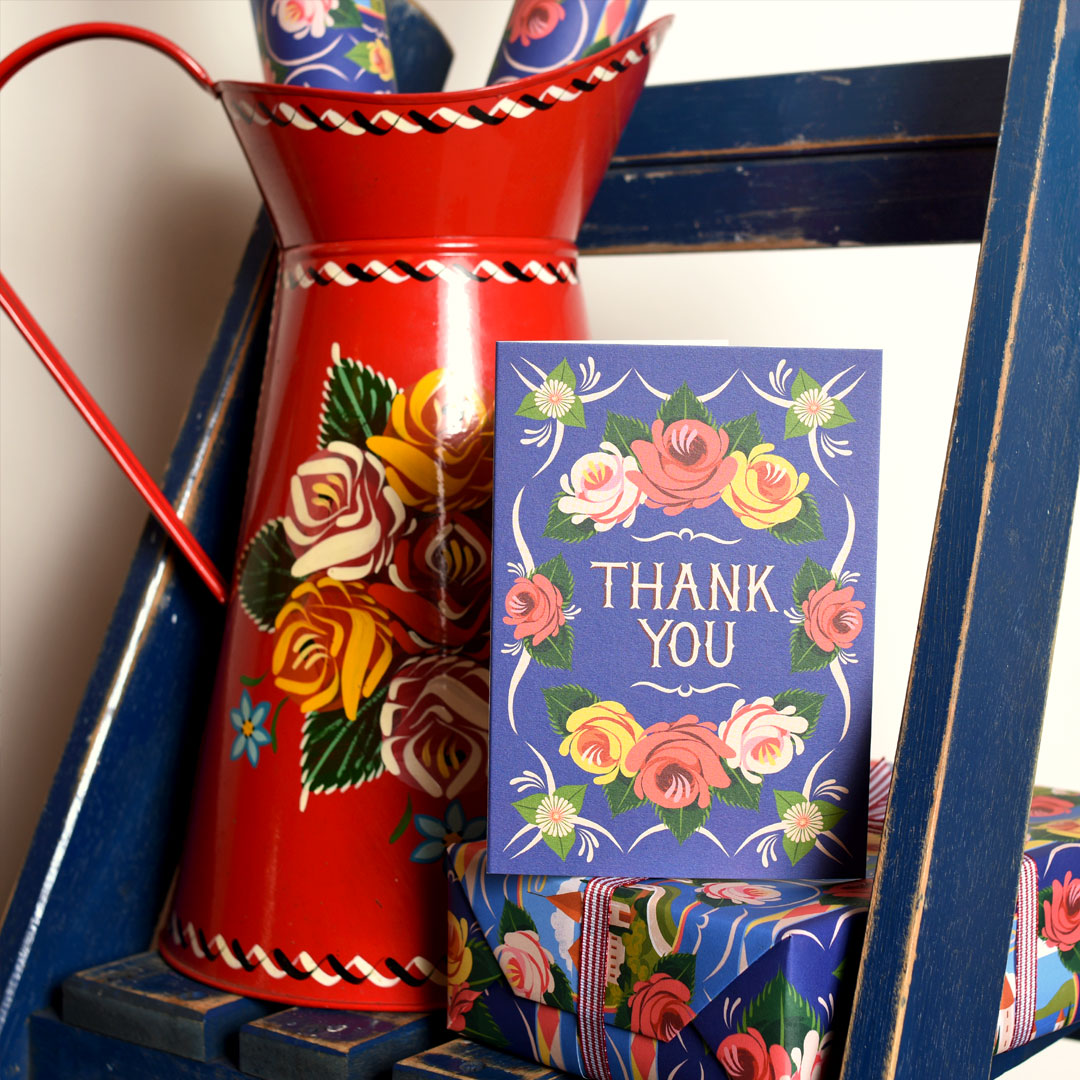 Decorative Floral Card with blue background and text reading 'Thank You', set against a floral painted red jug.