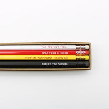 Four pencils in a kraft box on a white background. The pencils are white, red, yellow, and black, each printed with a humorous phrase from Only Fools & Horses.