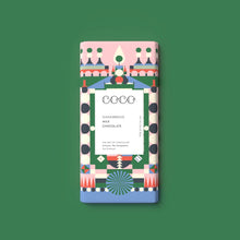 A rectangular milk chocolate bar with a colorful geometric pattern wrapper, centered on a solid green background. The wrapper features a white center label with the brand name 'COCO' and the text 'GINGERBREAD MILK CHOCOLATE'.