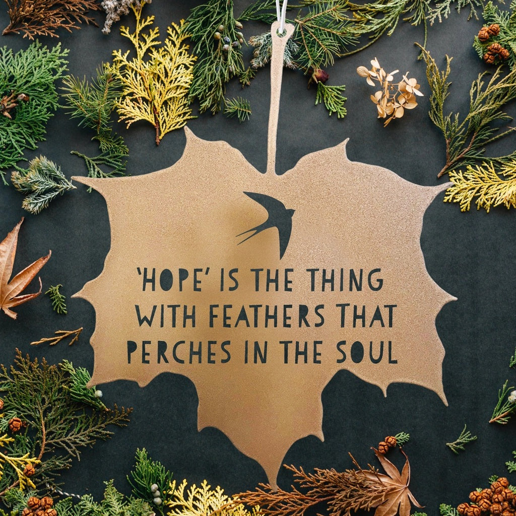 Decorative leaf-shaped sign with a quote surrounded by natural elements on a dark background