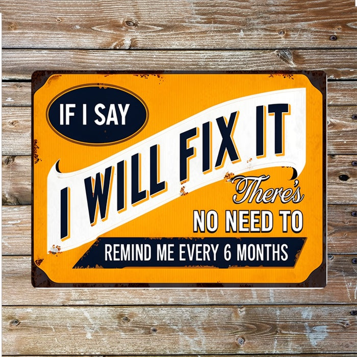 A rectangular vintage-style metal sign with a distressed orange background and bold white and black text reading, 'IF I SAY I WILL FIX IT There's NO NEED TO REMIND ME EVERY 6 MONTHS,' shown against a rustic wood plank backdrop.