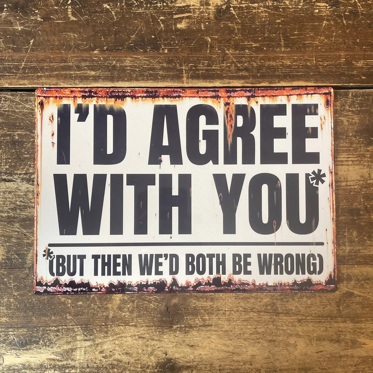 Rustic metal sign with humorous text on a wooden background