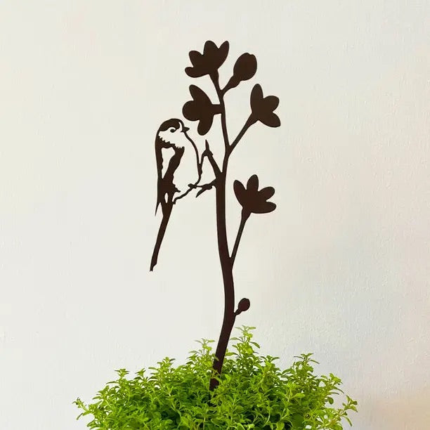 Metal pot stem with long tailed tit and flower stem.