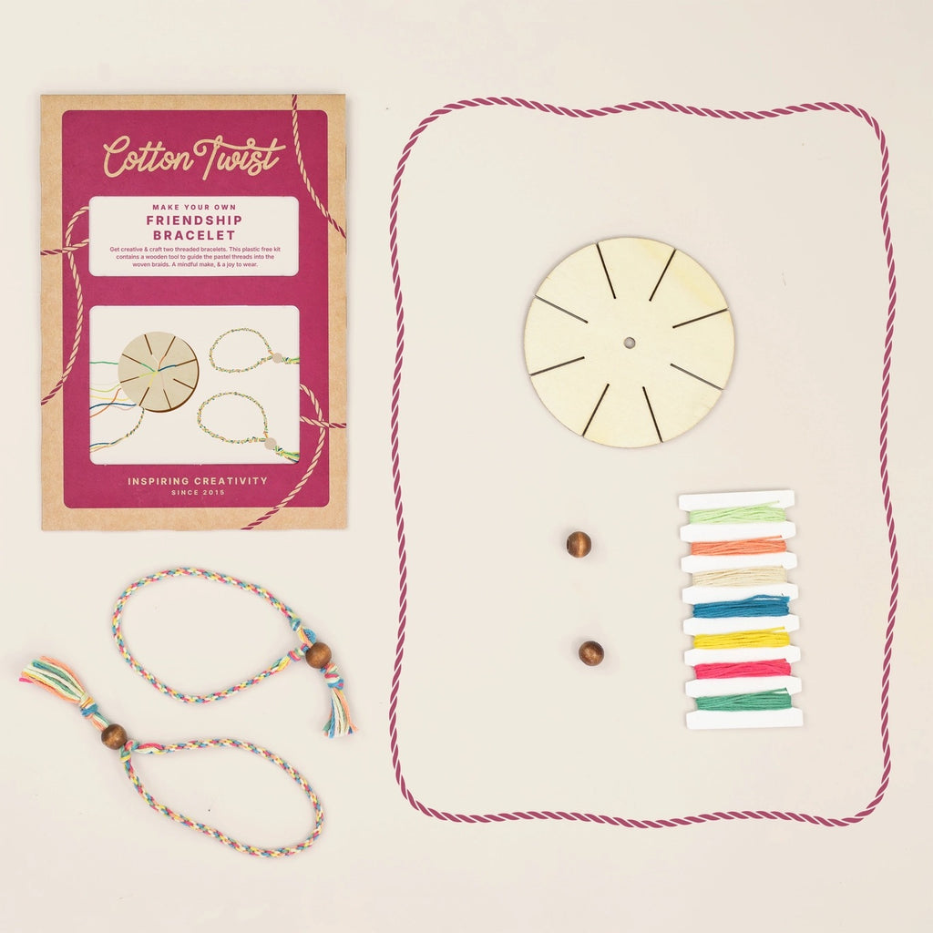 Cotton Twist friendship bracelet making kit with packaging, wooden wheel, colorful strings, and a completed bracelet on a beige background.