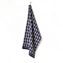 Navy blue towel with white owl pattern hanging on a white background