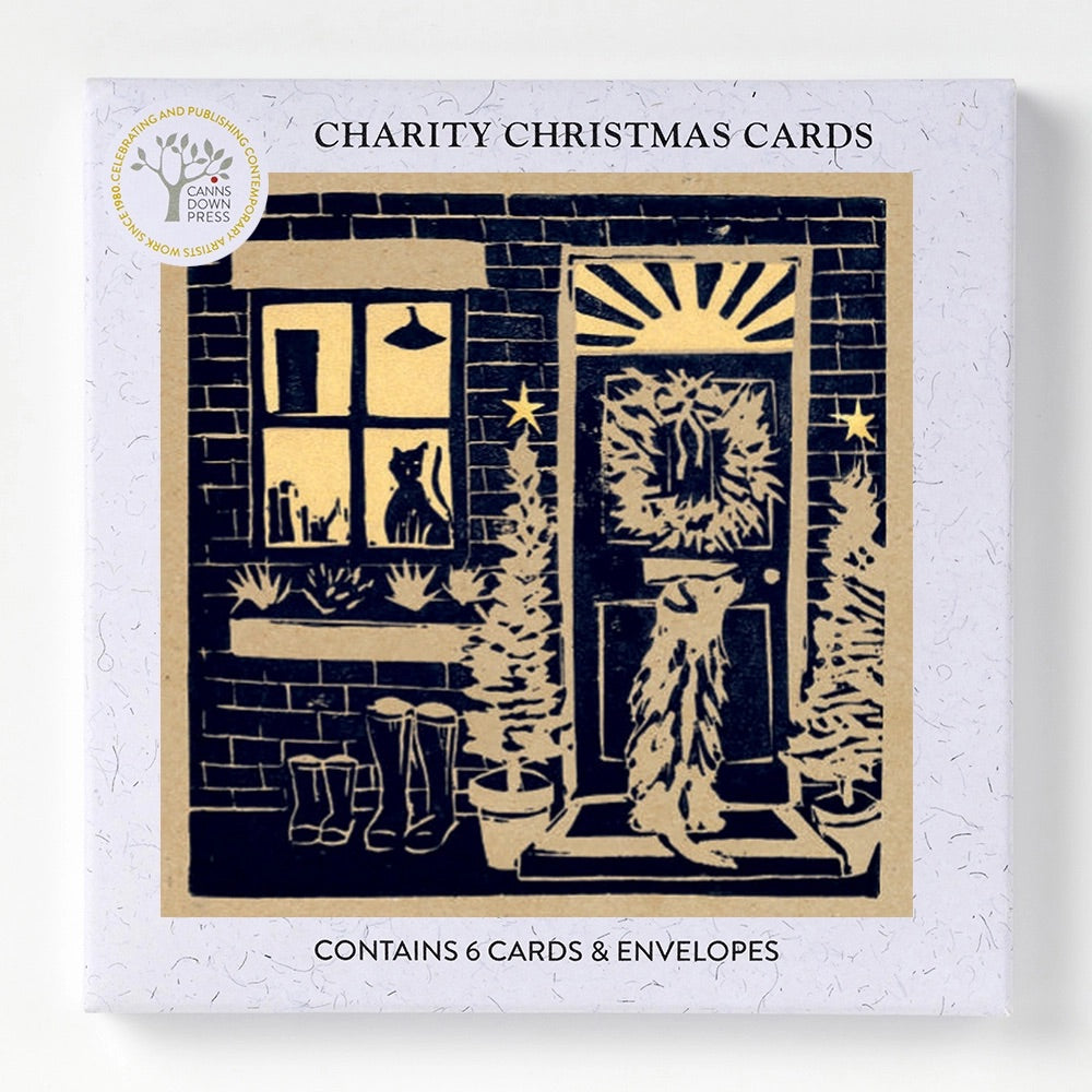 6 Charity Christmas Cards boxed featuring a black and beige woodcut-style illustration of a front door, window with a cat, boots, and Christmas trees, all welcoming the return from a winter's walk.