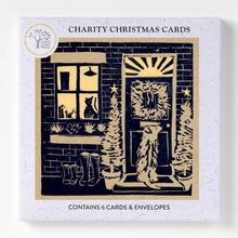6 Charity Christmas Cards boxed featuring a black and beige woodcut-style illustration of a front door, window with a cat, boots, and Christmas trees, all welcoming the return from a winter's walk.