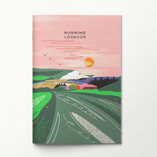A running logbook with a colourful illustrated cover showing a landscape with green fields, hills, a pink sky, and an orange sun. The title 'RUNNING LOGBOOK' is printed at the top.