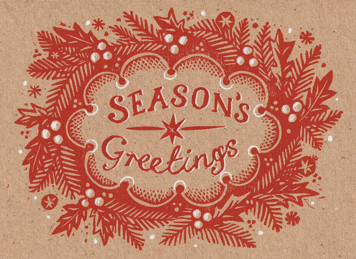 A vintage-style holiday greeting card design with the words “Season’s Greetings” in red lettering, surrounded by a red wreath of pine branches, berries, and snowflake motifs on a warm tan background.