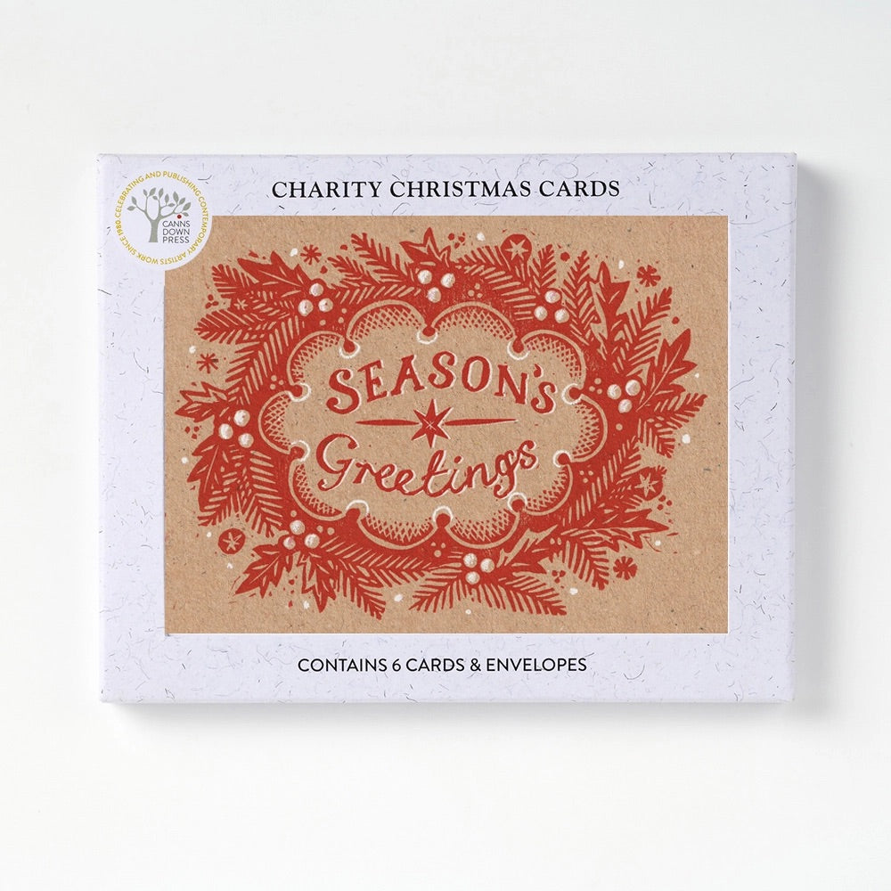 Charity Christmas Cards box featuring a red decorative holiday wreath and the words 'SEASONS GREETINGS' on a kraft paper-style card design.