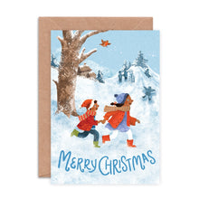 Christmas card with two people in winter clothing running in the snow, with 'Merry Christmas' text.
