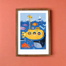 Framed children's illustration of a yellow submarine with sea creatures on a peach wall.