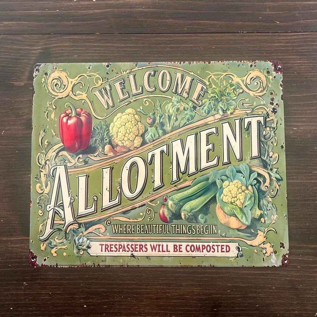 Decorative sign with 'Welcome to the Allotment' text and illustrations of vegetables on a wooden surface.