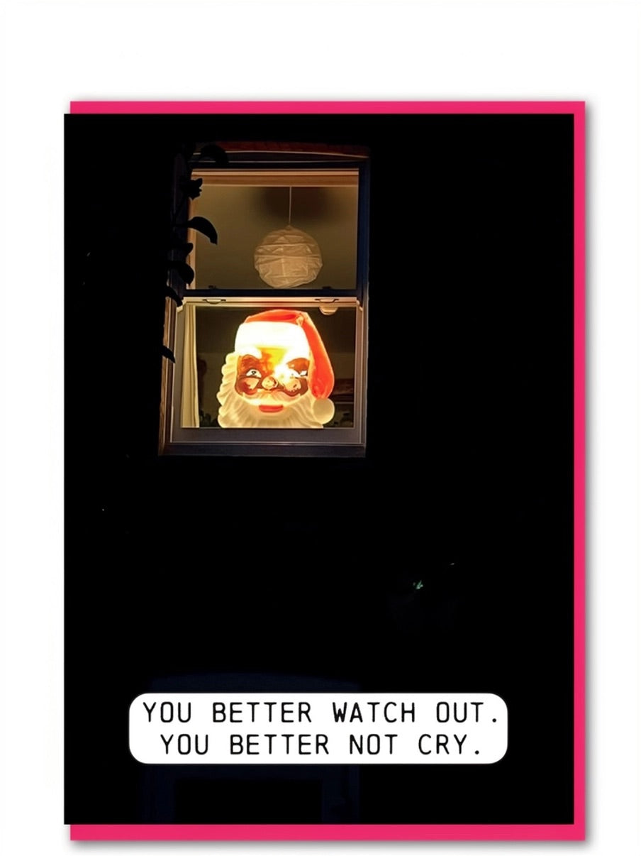A fun Christmas card or featuring a vintage Santa Claus figure decoration glowing in a window, surrounded by darkness. A white speech bubble at the bottom reads, 'YOU BETTER WATCH OUT. YOU BETTER NOT CRY.'